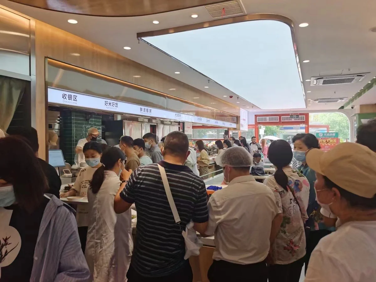 天添快客门店服务台，店员微笑迎客