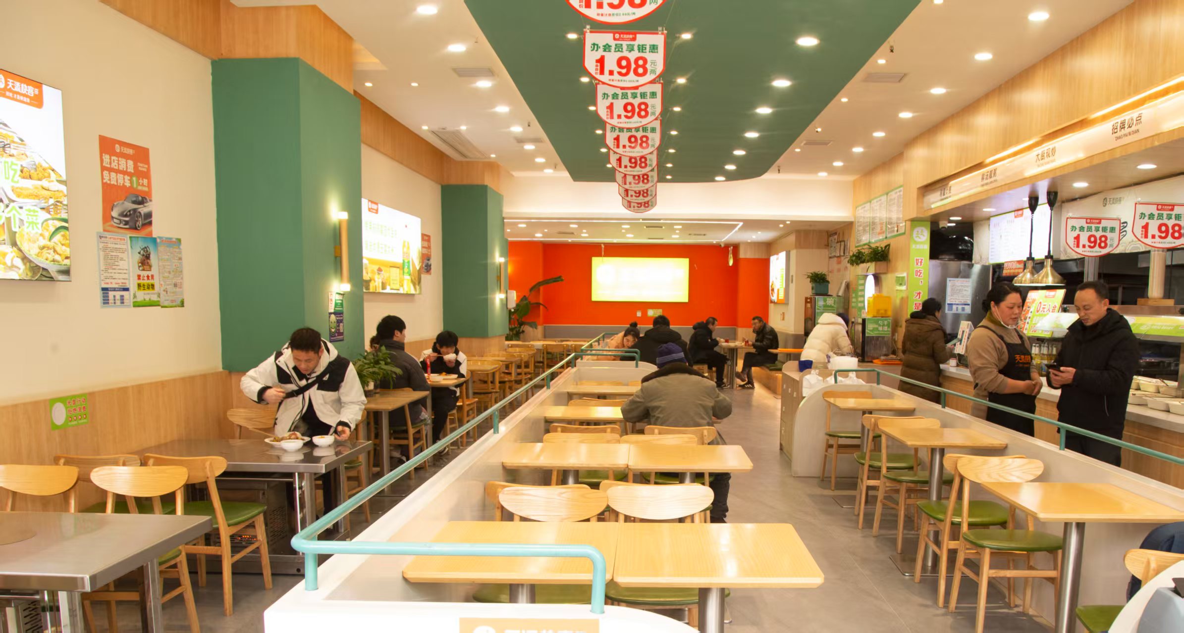 天添快客门店就餐区，绿色立柱与暖木桌椅